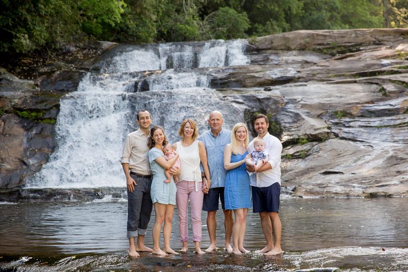 Family posing in front of a waterfall at the Hinoki House